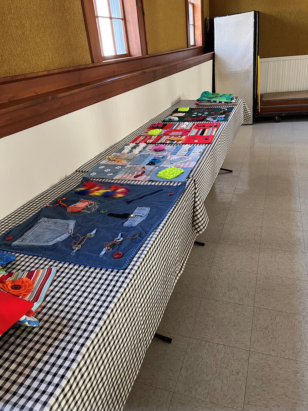Several dementia blankets displayed across a long table.